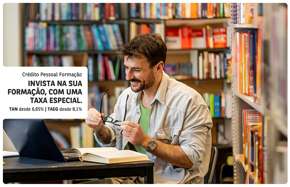 Crédito estudante: jovem a sorrir enquanto segura num livro