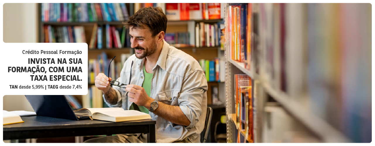 Crédito estudante: jovem a sorrir enquanto segura num livro